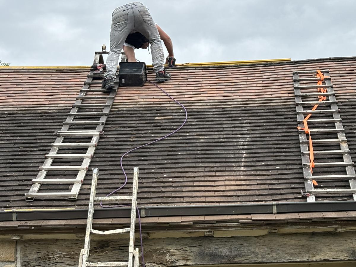 Artisan en action sur une rénovation de toiture en Corrèze